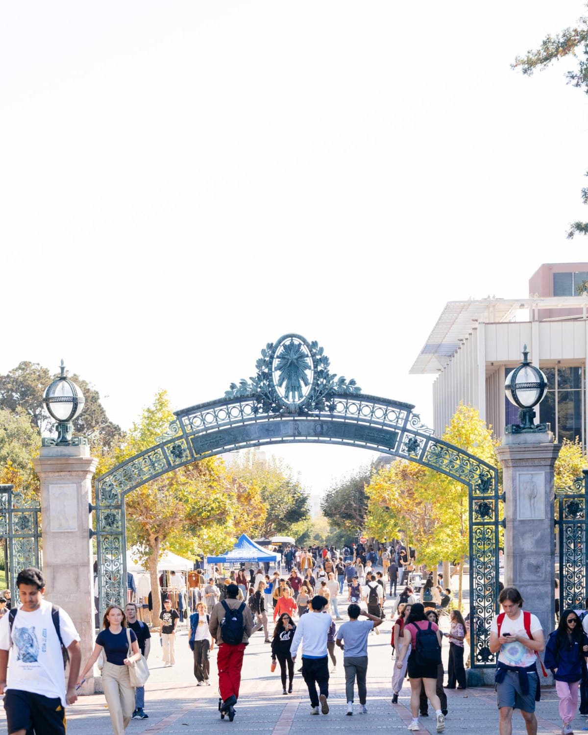 Students walking through Sather Gate at UC Berkeley on a sunny afternoon.